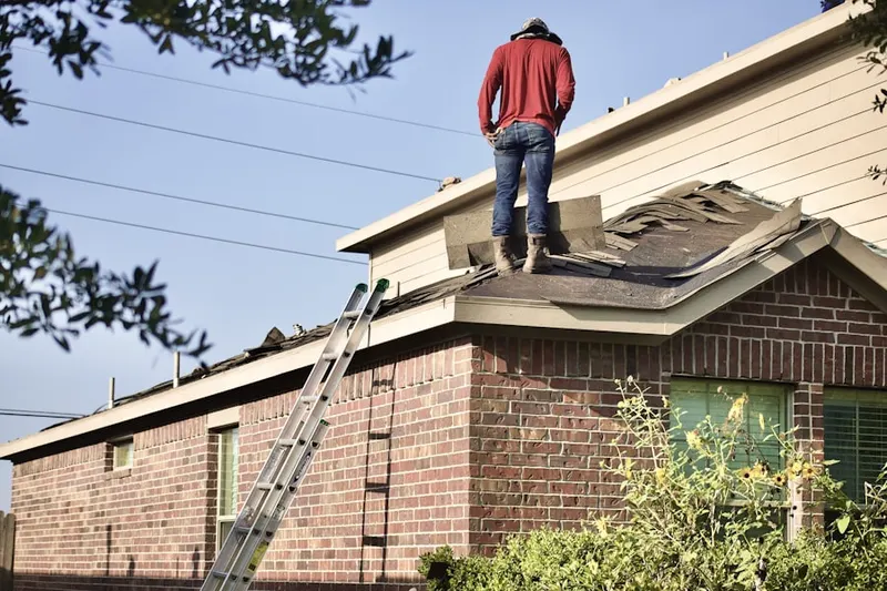 Professional roofer working on a residential roof in Griesmer Addition